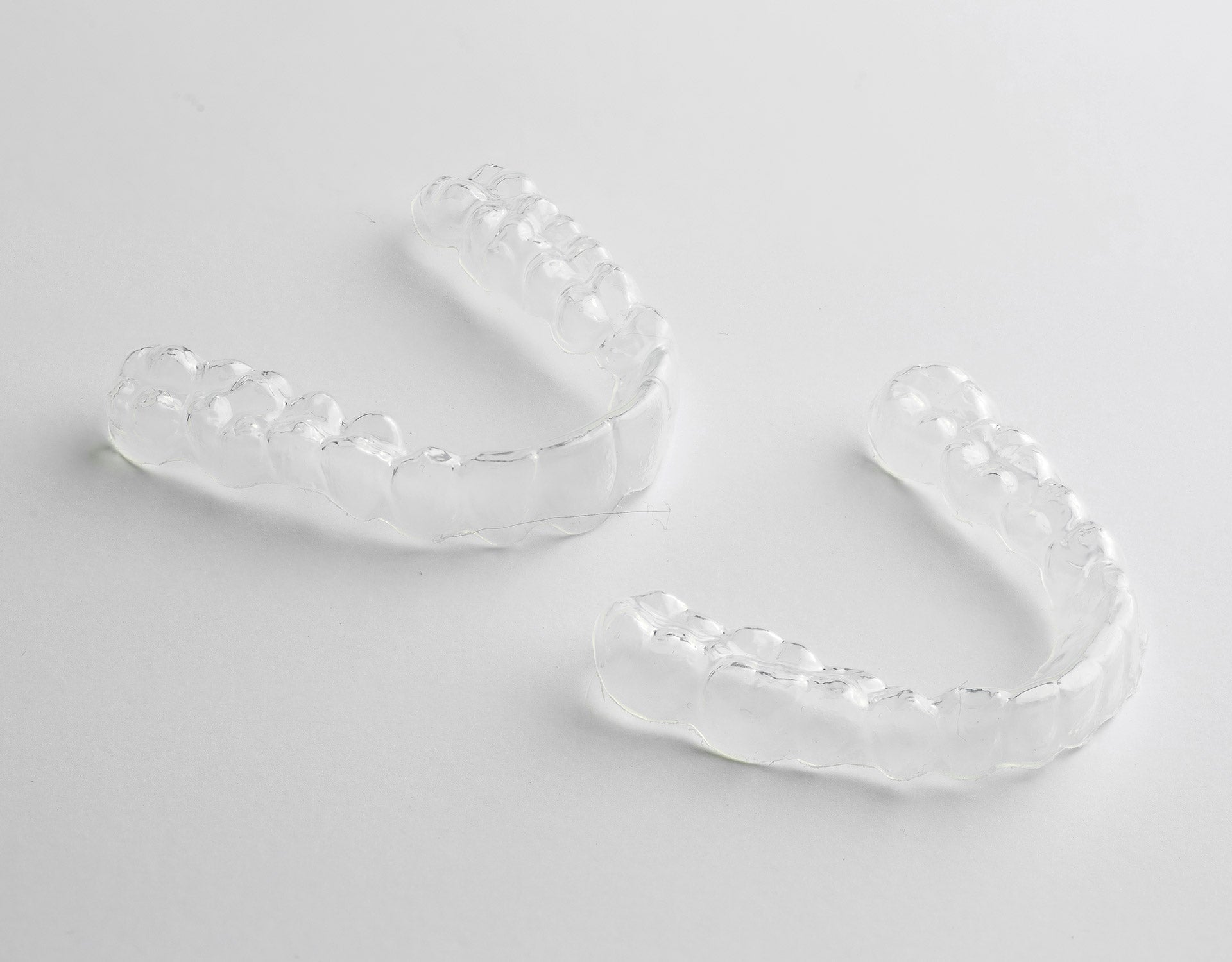 Two Custom Clear Retainers showcased on a white background, emphasizing their clear, durable design, best retainers for after-braces dental care - Snap Custom Nightguards